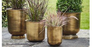 Brass outdoor planters used as part of the quiet luxury garden trend