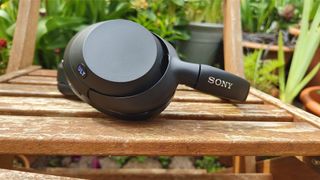 Sony ULT Wear over-ear headphones side-on view of earcup on wooden outdoor table