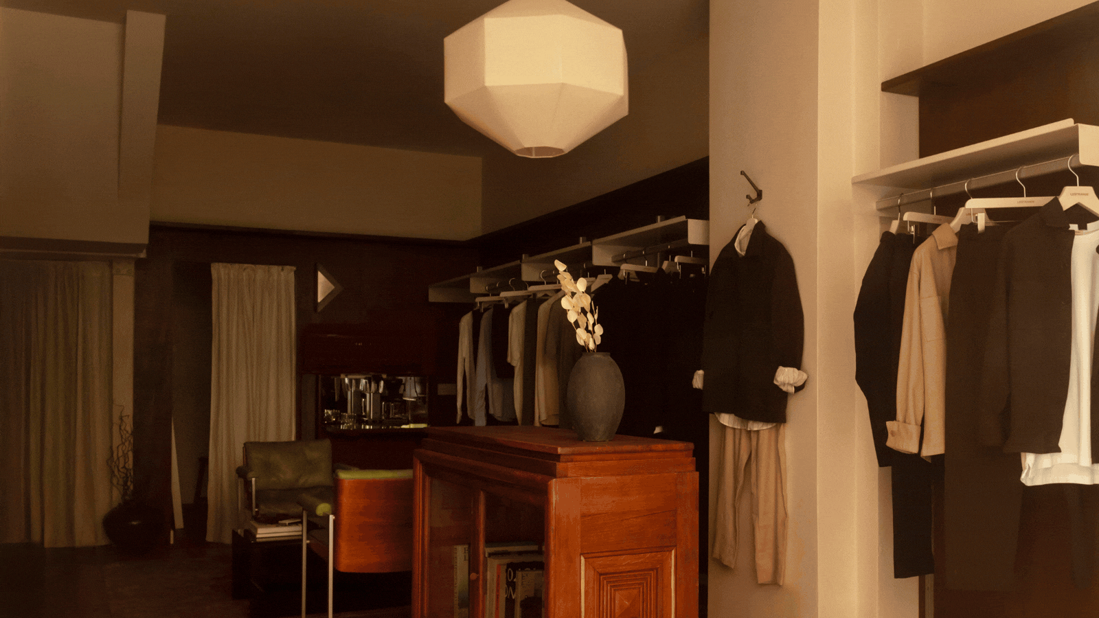 A recurring gif spotlighting different corners, across full shots and close-ups, of a sleek menswear store clad in warm woods, beige drapery, and silver and mint green accents.