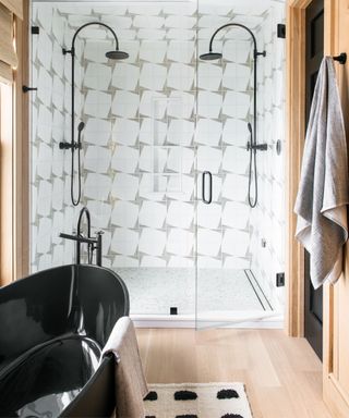 White tiled shower with twin black shower heads, black bath