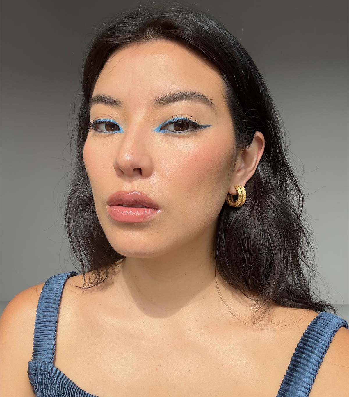 Marcela Alcala wears a sleek blue eyeliner look with a bronzed complexion.