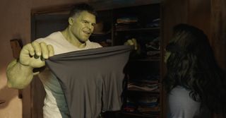 Smart Hulk (Mark Ruffalo) holds up a pair of spandex pants for She-Hulk (Tatiana Maslany), pulling them taut at the waist to demonstrate their stretchability. He looks quite pleased with himself.