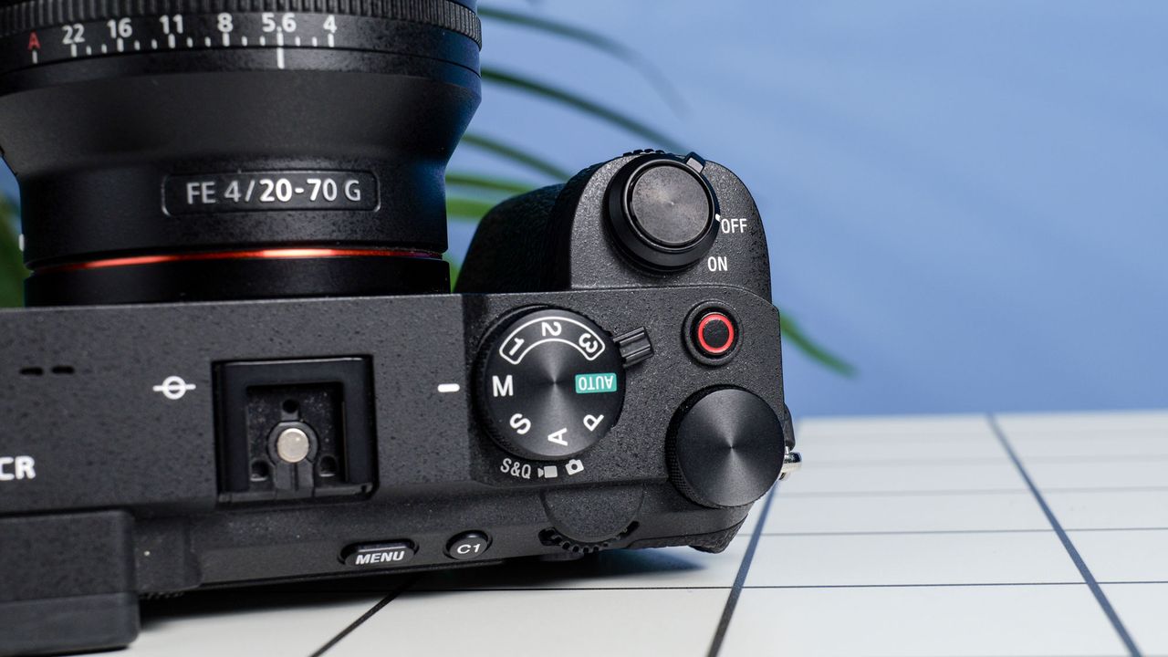 The Sony A7CR on a white table with a blue wall in the background