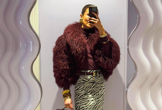 Nina Sandbech in a burgundy faux fur jacket, bag, and tights with a zebra print skirt.