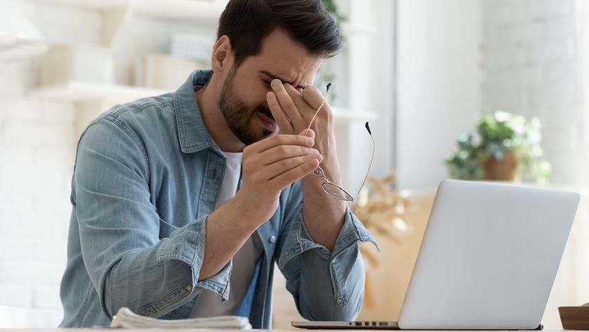 Person with eye strain working on laptop