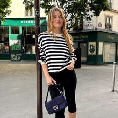 French influencer wearing a striped shirt and capri pants