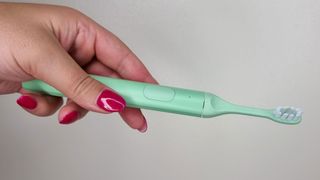 Suri electric toothbrush being tested by our reviewer