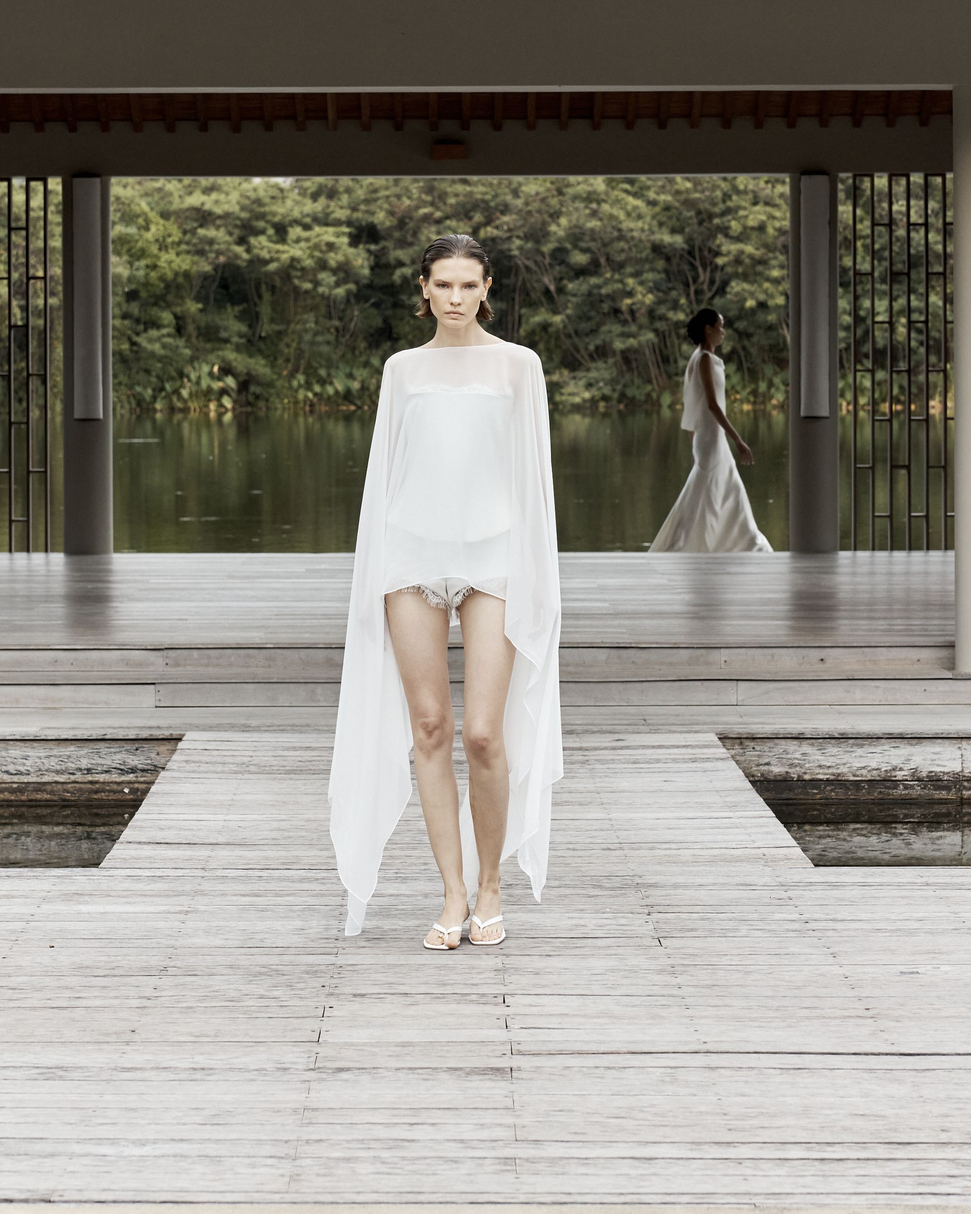 A woman wears a white cape.