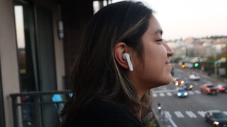 A female reviewer wearing Urbanears Alby earbuds