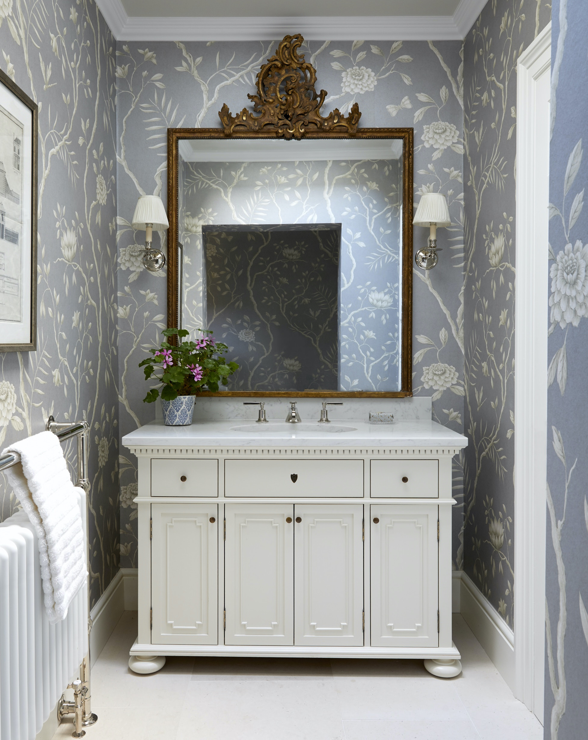 Blue wallpaper with rose bush design, white sink cabinet