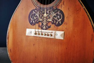 Ivory pyramid bridge and mandolin-style pickguard: pickguards first appeared on special order guitars around the turn of the century but didn’t become standard until the 1930s.