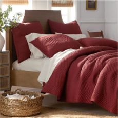 Red and white bedding on a wooden bed frame