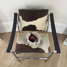 An image of a makeup bag full of products sitting on a chair.
