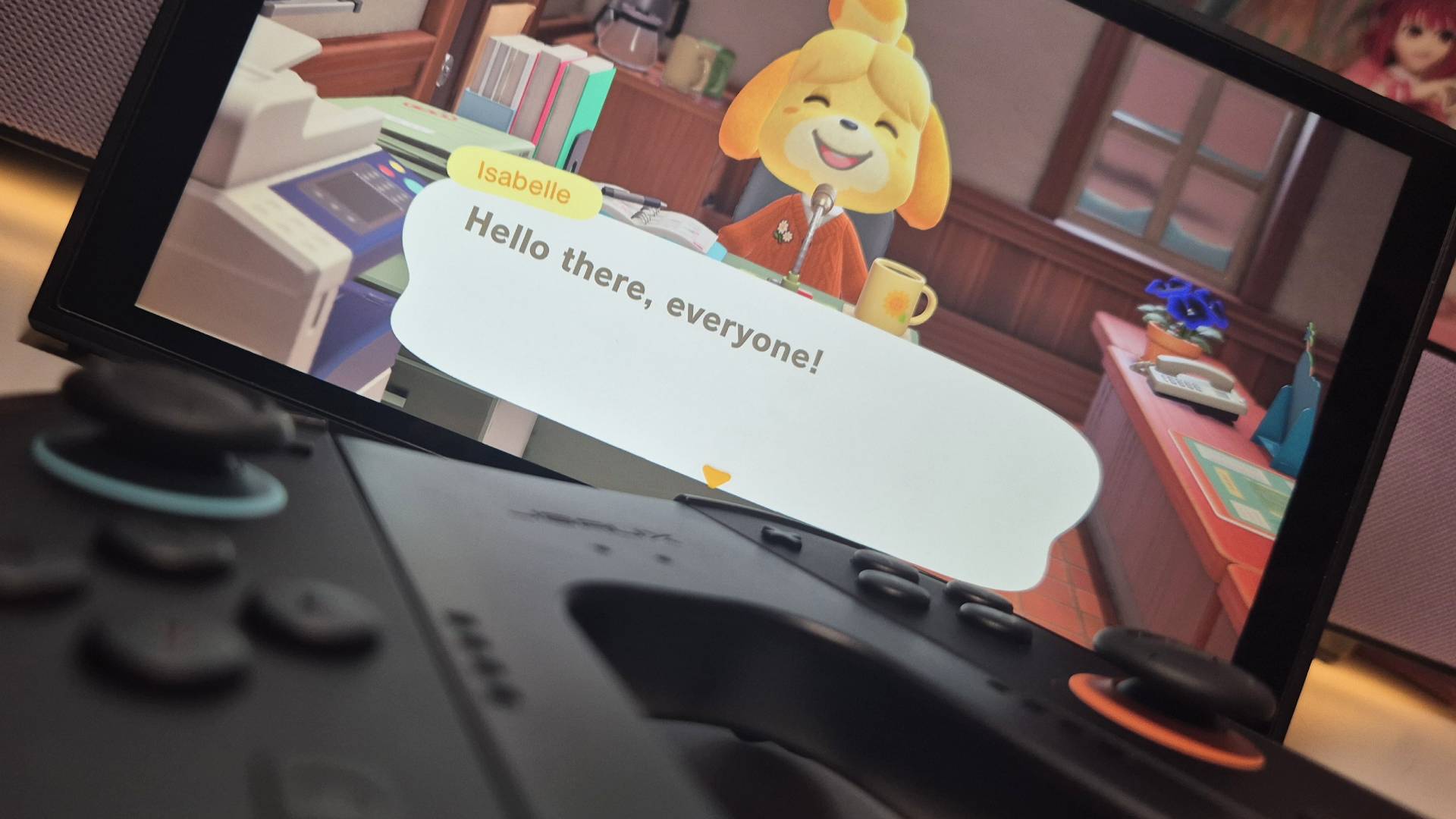 Photo of the JSAUX Switch 2 Charging Grip sitting in front of the handheld playing Animal Crossing New Horizons.