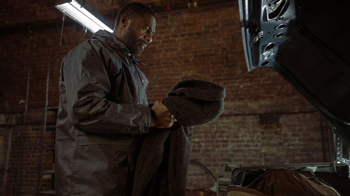 Luther (Idris Elba) holding his coat in Luther: The Fallen Sun