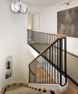 black railing staircase with wooden banister and matching stair runner