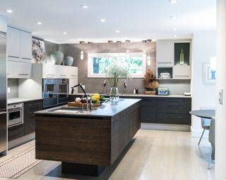 Kitchen with central dark wood island and sink and round dining table