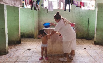Woman washing a little girl in prison