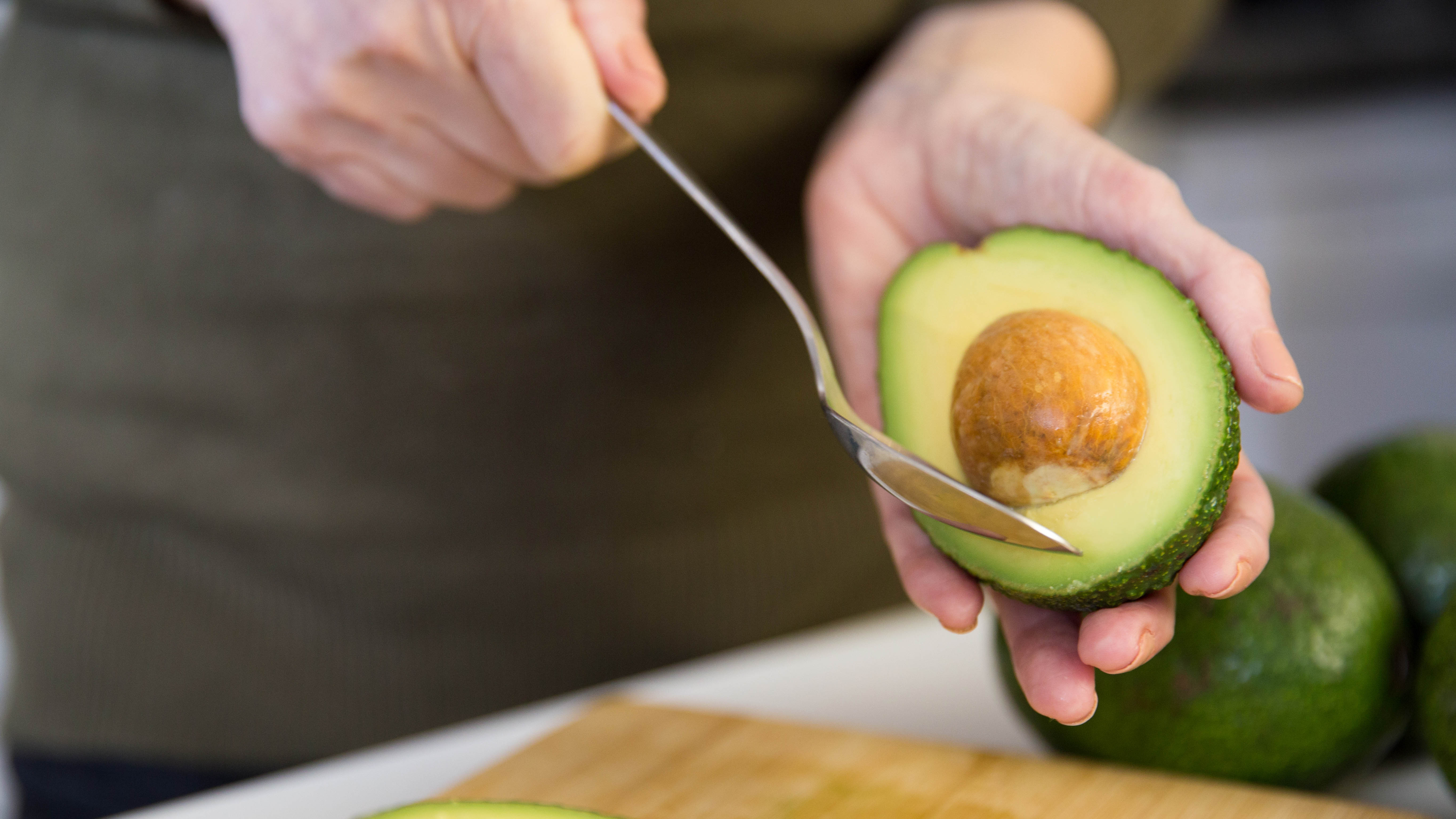 The seed being removed from an avocado with a spoon