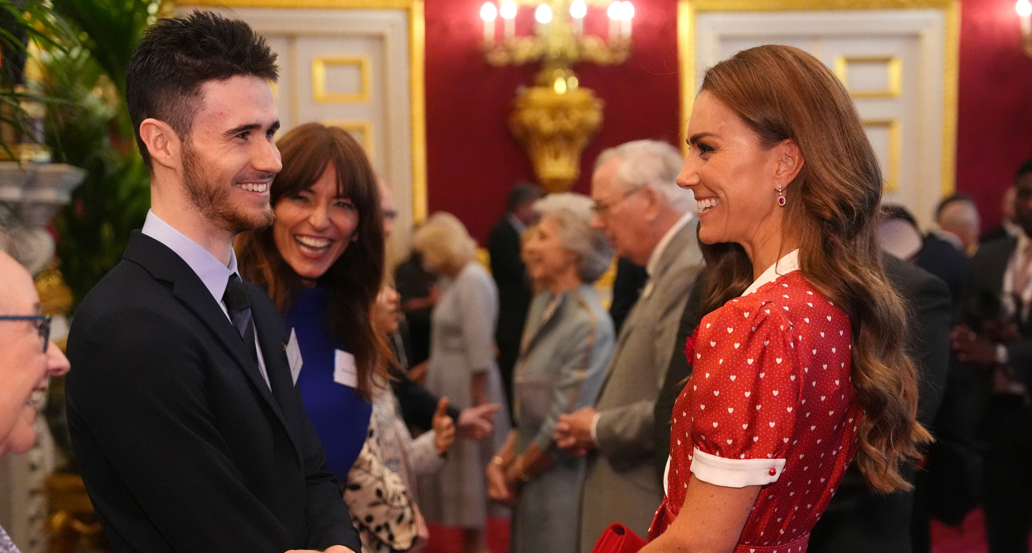 Princess Kate wearing a red dress and laughing 