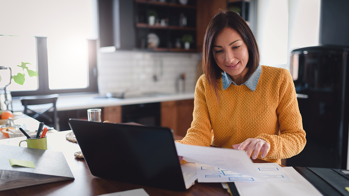 Woman working on laptop in kitchen