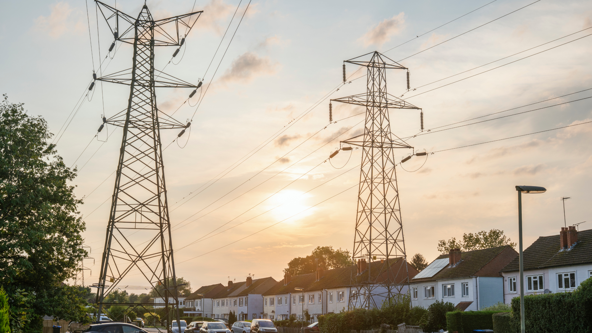 residential street at sunset with electricity pylons 