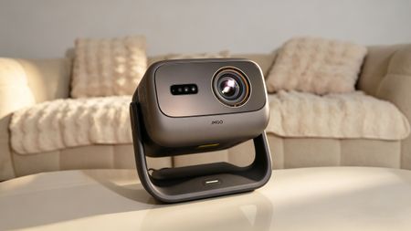 JMGO N3 Ultimate projector on a coffee table in a neutrally decorated living room
