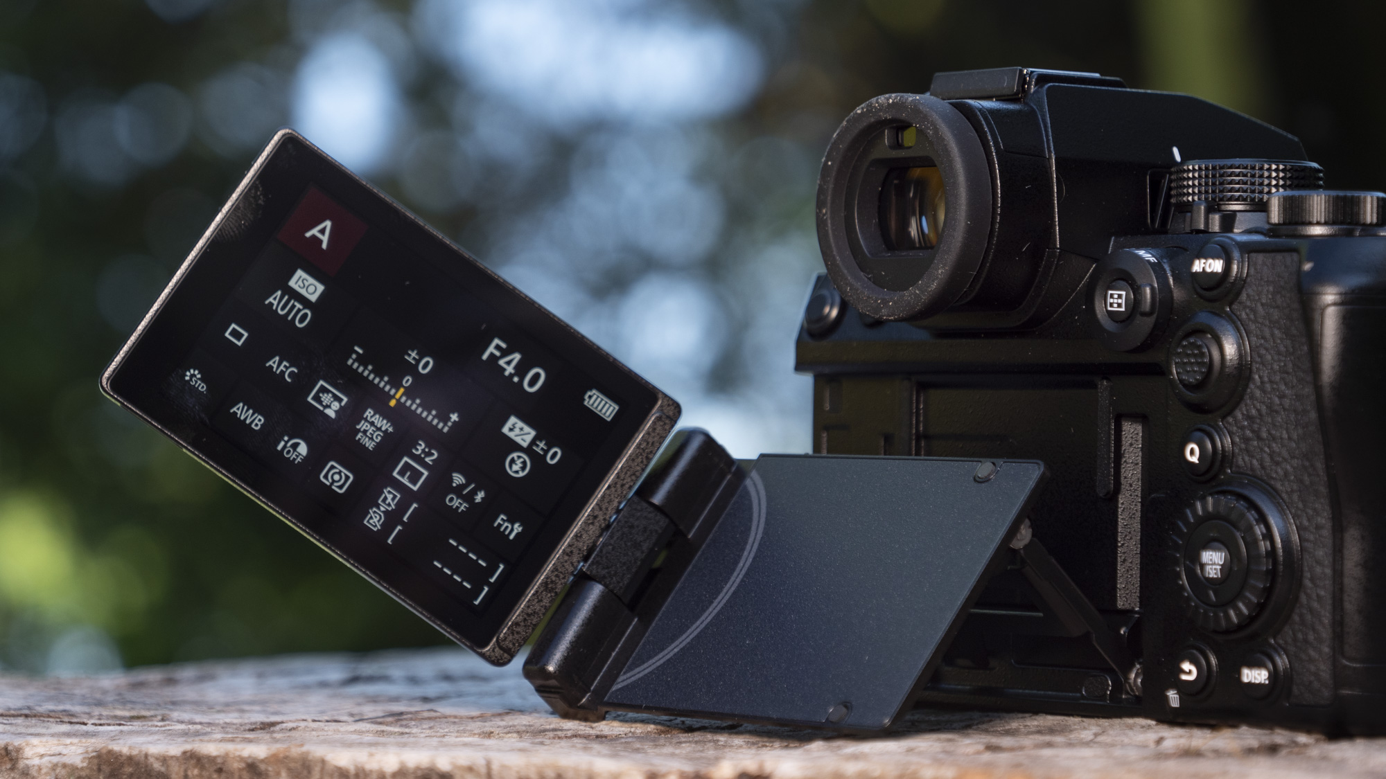 Panasonic Lumix S1 II mirrorless camera outdoors on a wooden surface, touchscreen flipped out