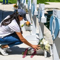 Meghan Markle, the wife of Britain's Prince Harry, places flowers as she mourns at a makeshift memorial outside Uvalde County Courthouse in Uvalde, Texas, on May 26, 2022. - Grief at the massacre of 19 children at the elementary school in Texas spilled into confrontation on May 25, as angry questions mounted over gun control -- and whether this latest tragedy could have been prevented. The tight-knit Latino community of Uvalde on May 24 became the site of the worst school shooting in a decade, committed by a disturbed 18-year-old armed with a legally bought assault rifle.