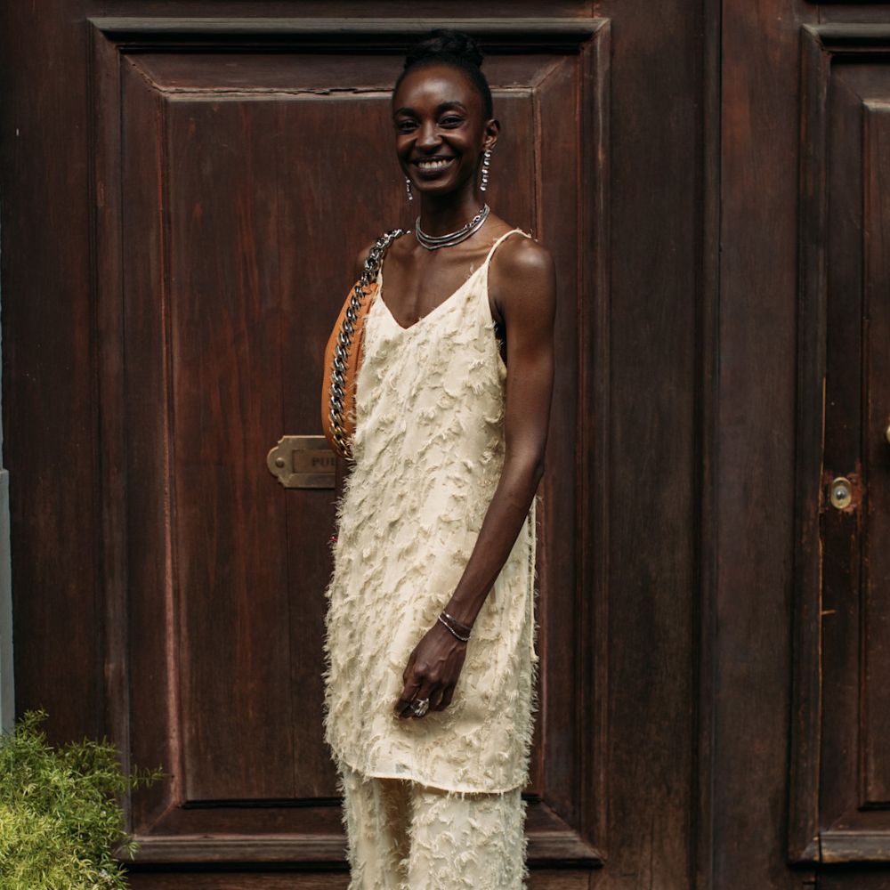 Menswear SS26 showgoer wears a textured butter yellow two-piece with apple green satin shoes in Milan.