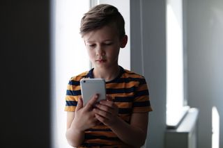 An unhappy boy with a smartphone