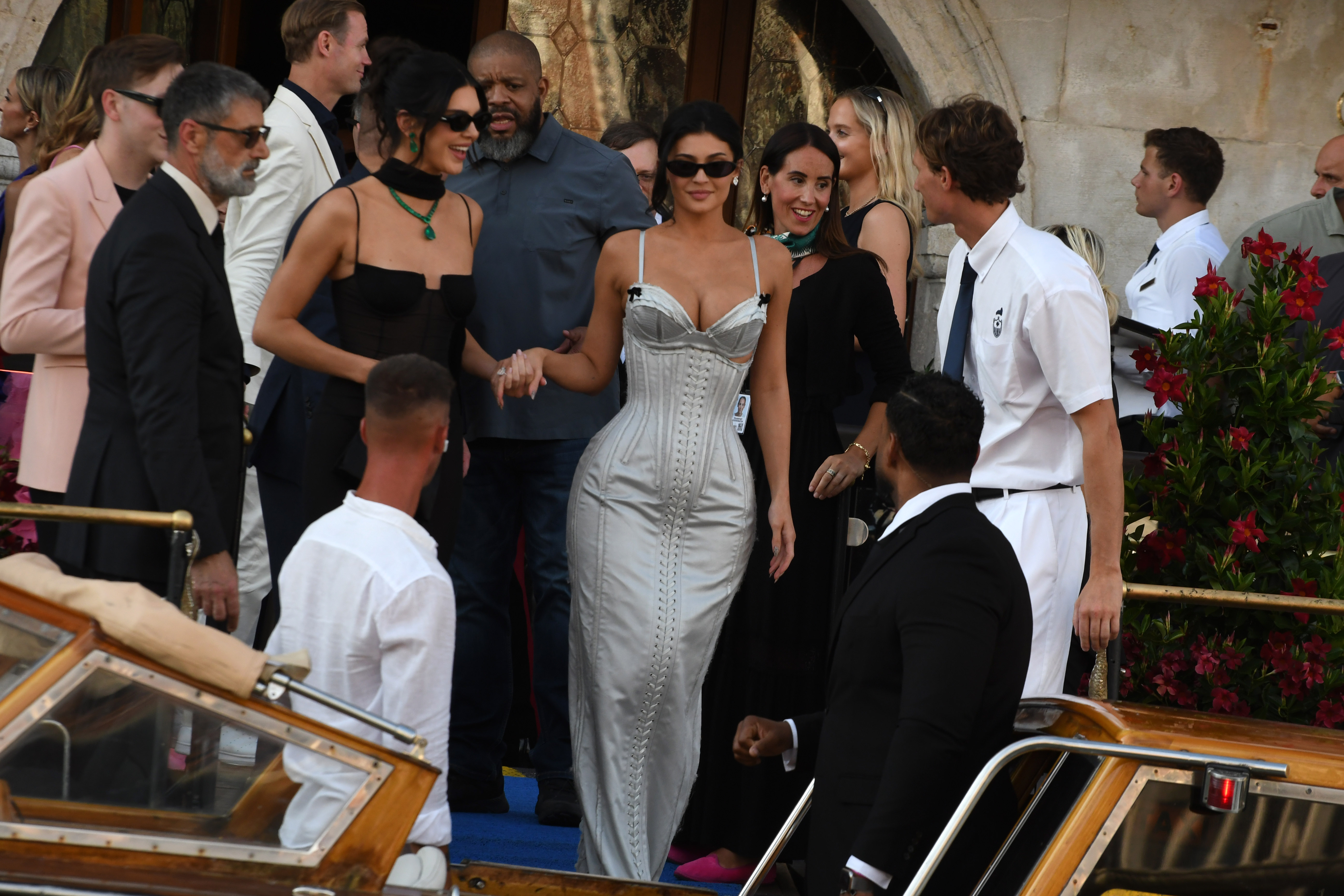 Kendall Jenner wears a sheer dress and Kylie Jenner wears a silver lace-up corset dress
