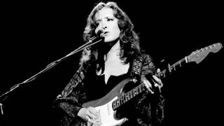 Bonnie Raitt performs on stage at Hammersmith Odeon, London, England, on August 6th, 1977. She is playing a Fender Stratocaster guitar. 