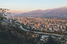 An aerial view of a large city with mountains behind