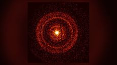 Image of the gamma-ray burst from the Swift observatory, showing a bright center surrounded by bands of orange circles.