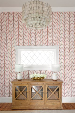 An entryway with a wallpaper in pink