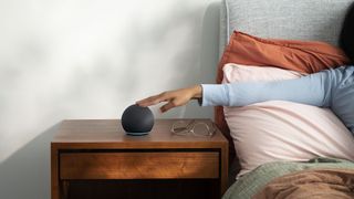 Amazon Echo Dot smart speaker on a bedside table