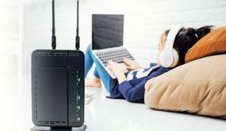 A home wireless router near a child using a laptop.