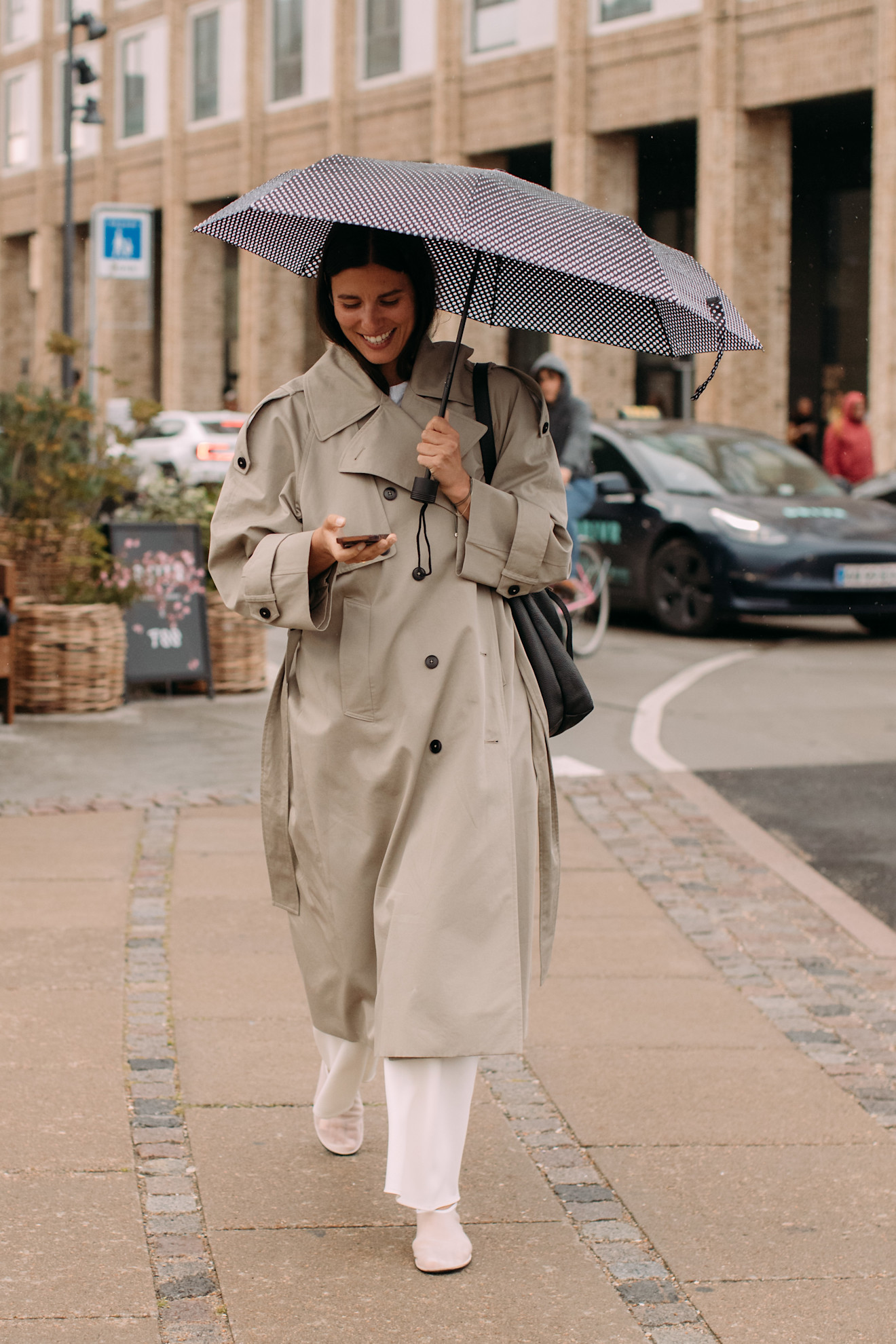 Woman wearing a chic trench coat outfit at Copenhagen fashion week