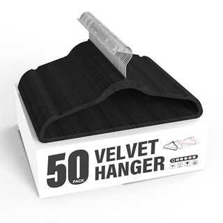 Black velvet hangers on top of the white box packaging with black graphic font stating 50 velvet hanger