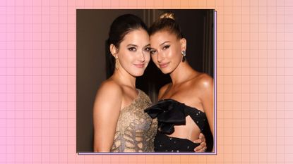 Alaia Baldwin wearing a gold dress, hugging her sister Hailey Bieber - who is wearing a black, strapless gown / on a pink and orange checked background