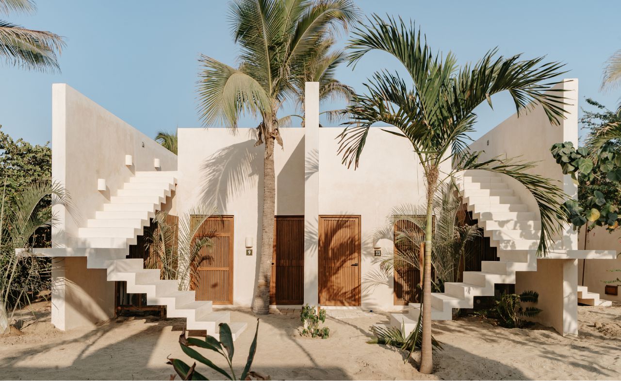 A white hotel surrounded by palm trees