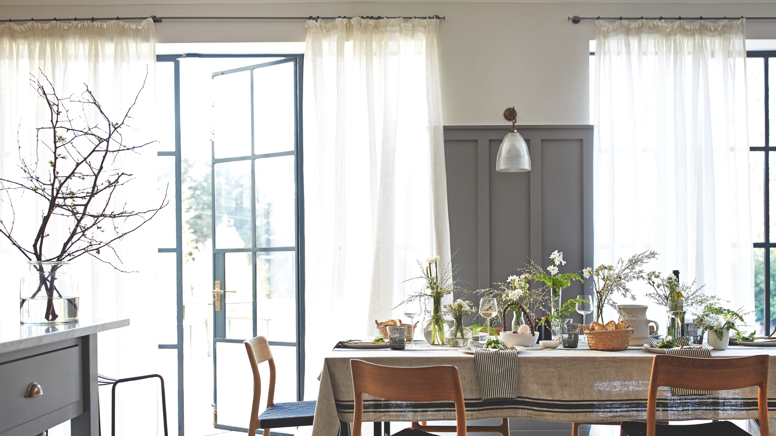 a dining room with sheer curtains covering the doors
