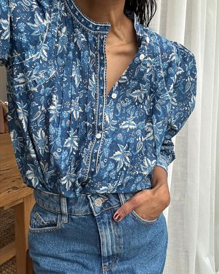 @monikh wearing a floral blouse with jeans