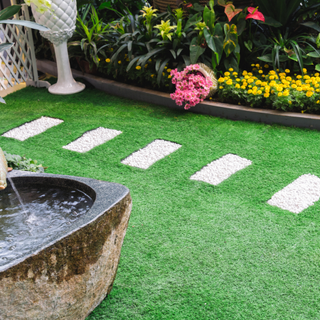 Water feature and flower bed on artificial grass