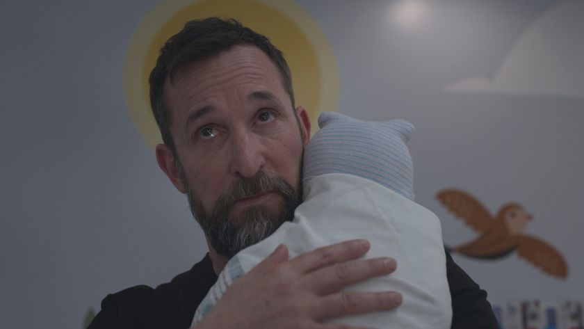 Noah Wyle holding a baby on The Pitt. 