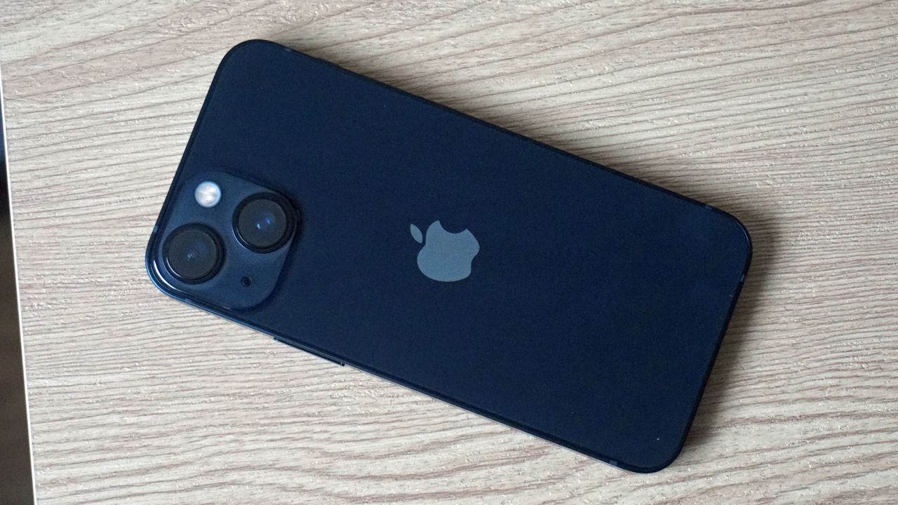 Blue iPhone 13 mini lying face down on a table