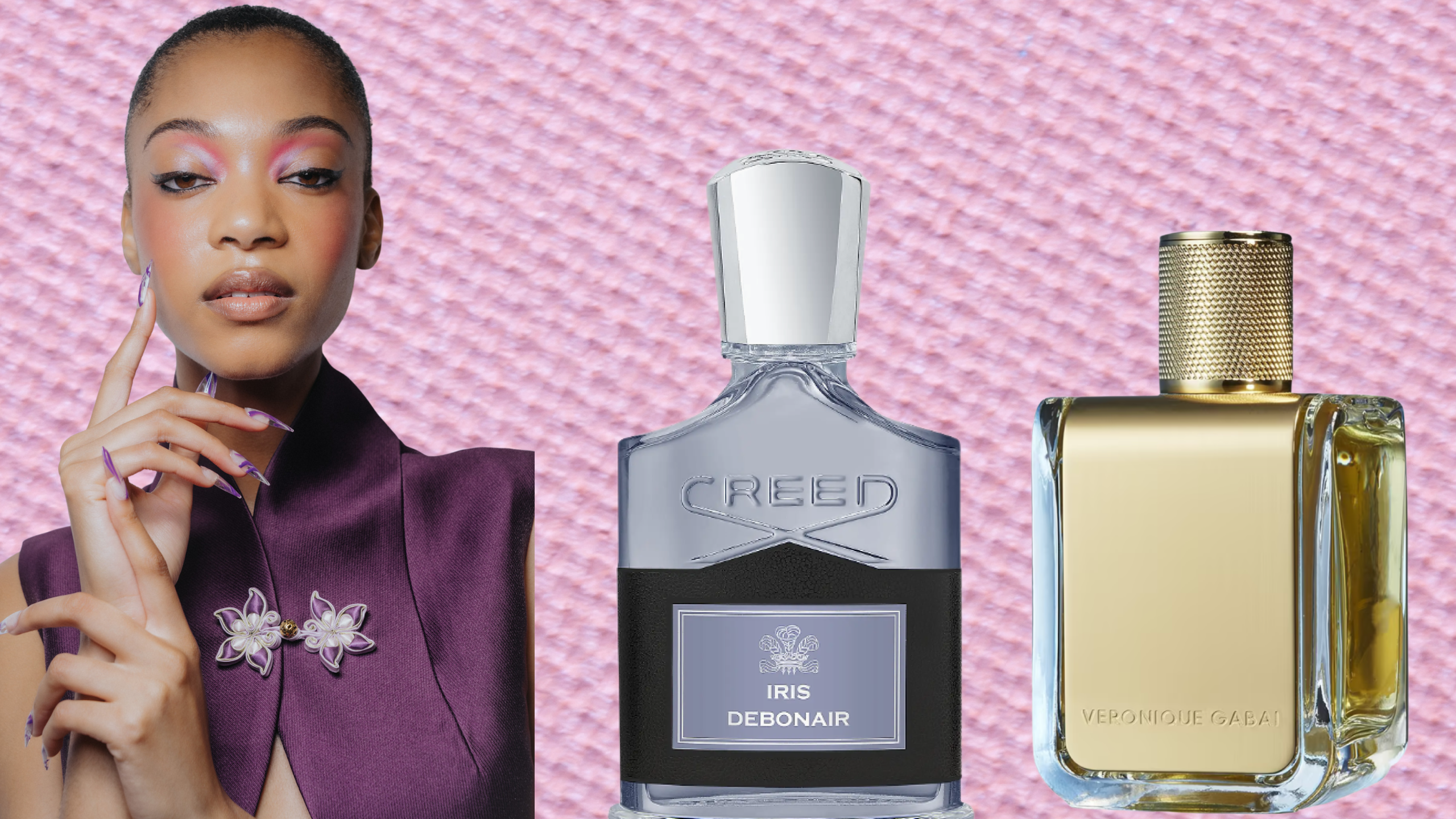 A woman wearing a purple tops, nails, and makeup next two two bottles of perfume all in front of a textured, light purple eyeshadow background. 