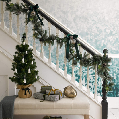 Small Christmas tree decorated with bells in a hallway.
