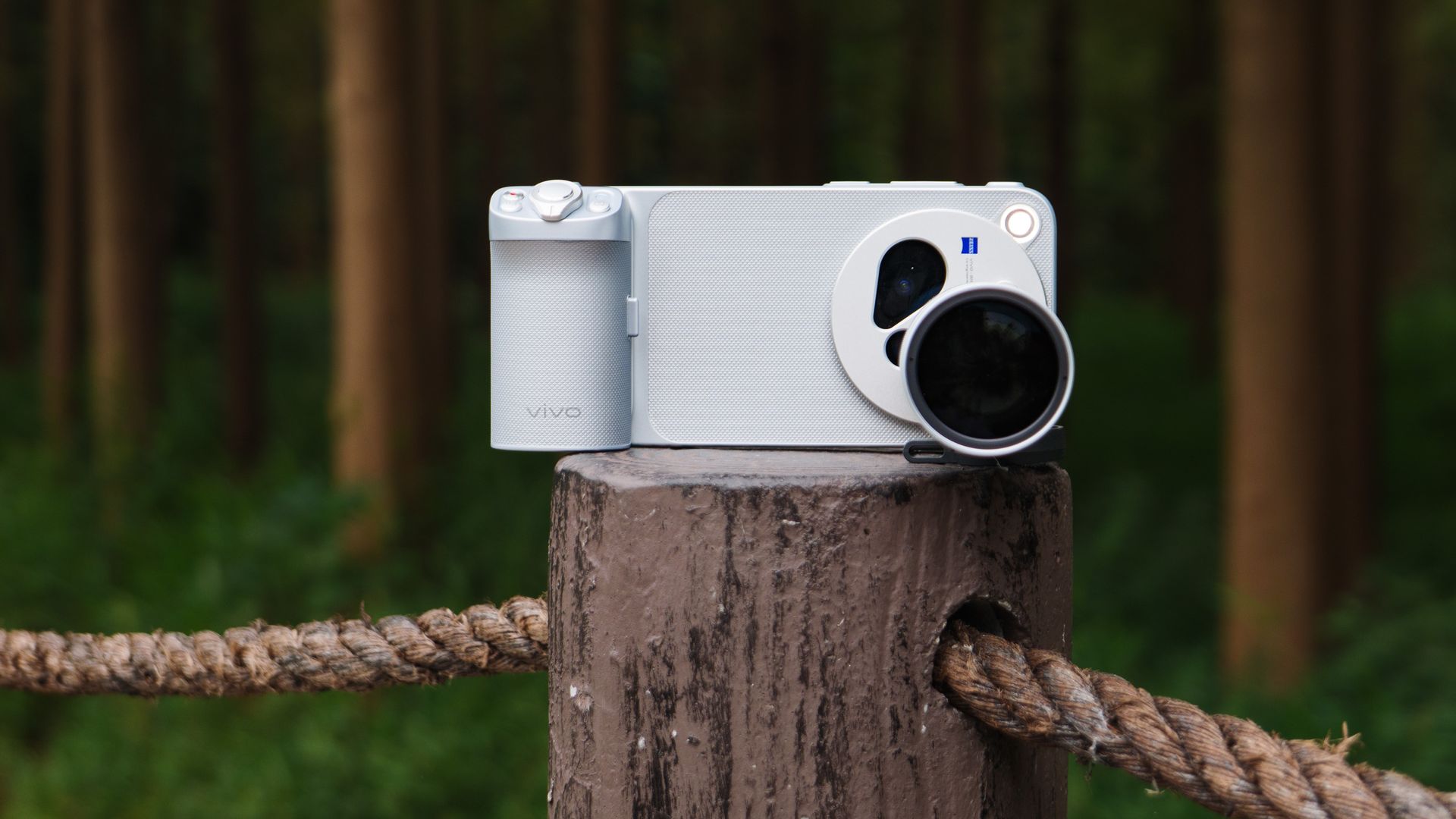 The Vivo X500 Pro Max phone with teleconverter lens attached, on a wooden post besides walkway in a birdlife reserve in Shanghai, China